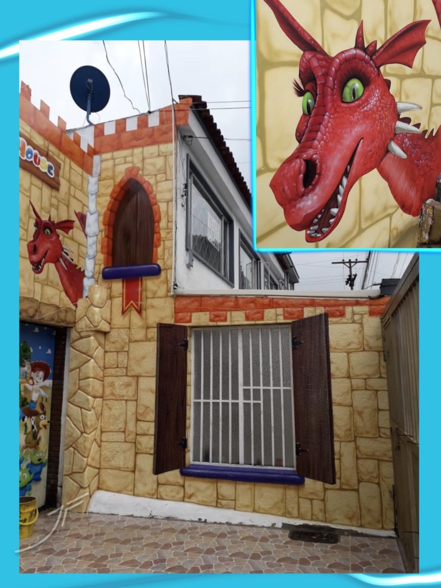 Fachada de un jardín infantil pintada como un castillo de piedra con un dragón rojo, con detalle del dragón