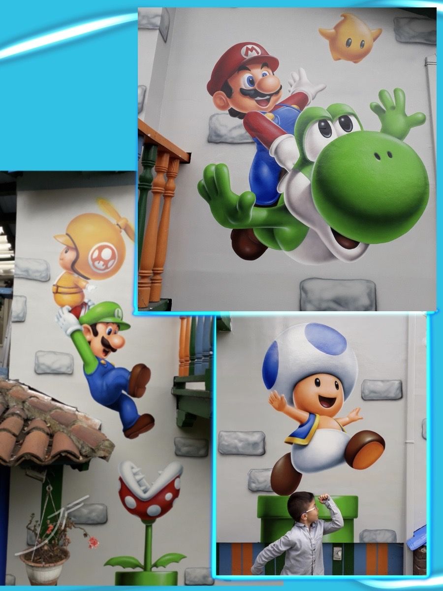 Murales de personajes de videojuego saltando sobre una pared de patio, con tuberías y una planta piraña
