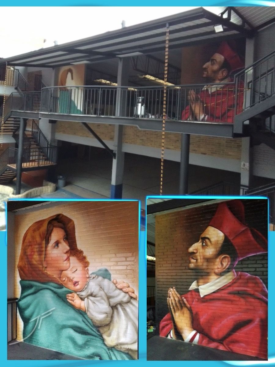 Patio de colegio con murales sobre muro de ladrillo de una madre con su hijo y una figura religiosa orando