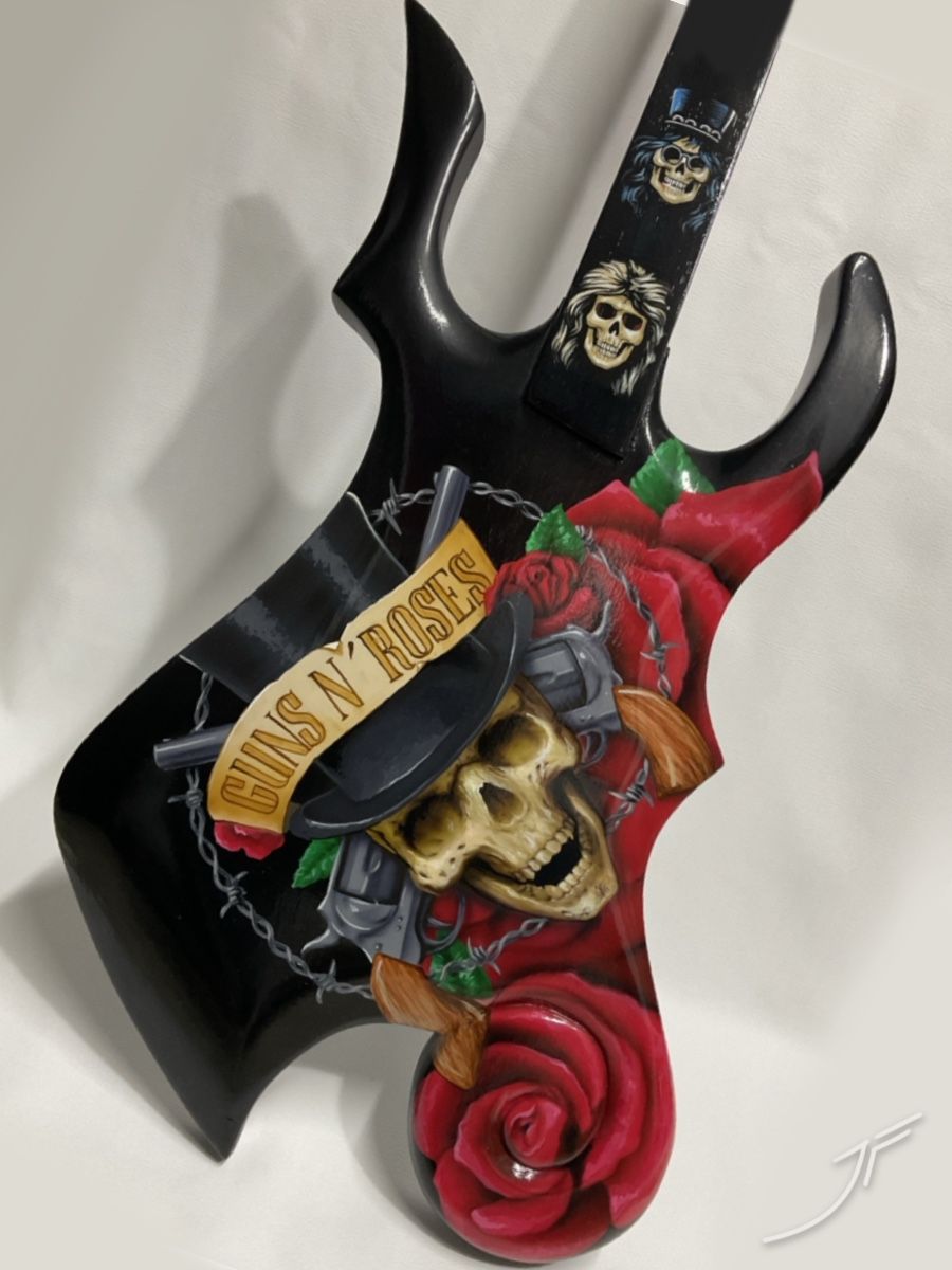 Guitarra negra pintada con una calavera con sombrero, rosas y revólveres